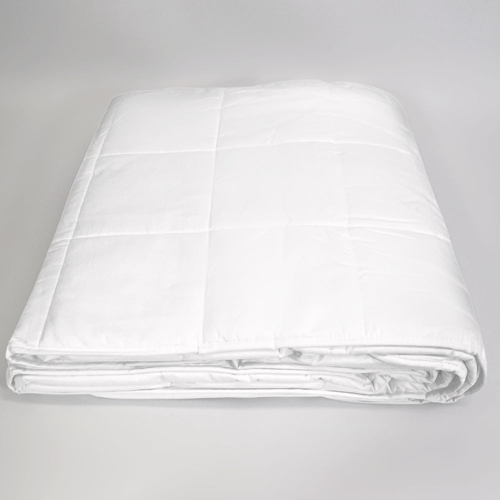 A folded white quilted comforter or mattress protector, photographed on a seamless light gray studio background.