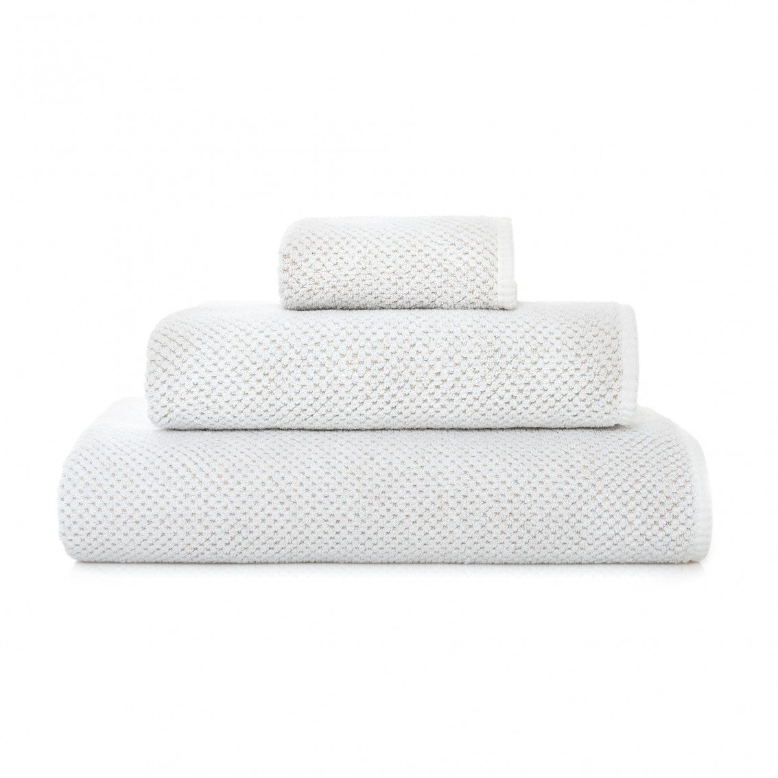 Set of three textured towels stacked on a white background