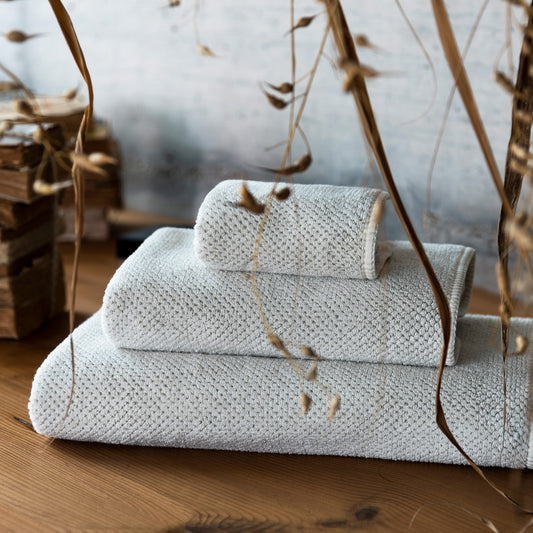 Stack of textured towels on a wooden surface with decorative elements