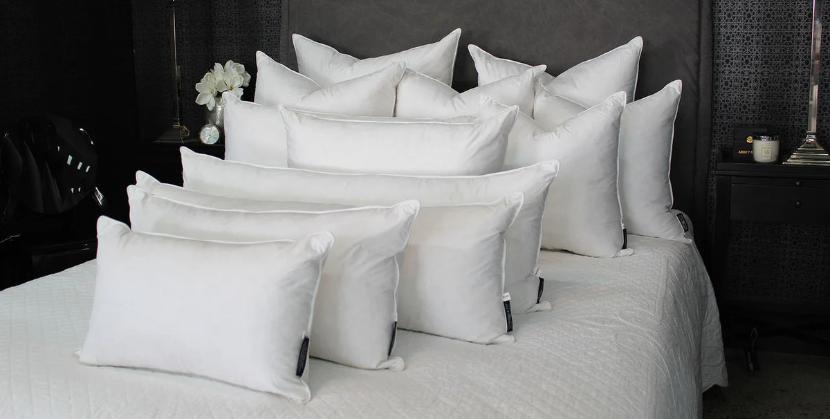 A collection of cushion & pillow inners on a bed.