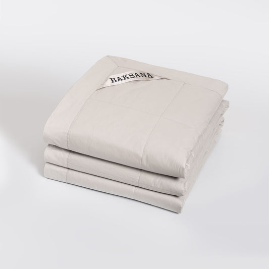 A  coverlet called Luxury Espresso in Linen colour that looks like cream with 'BAKSANA' branding on a white background.